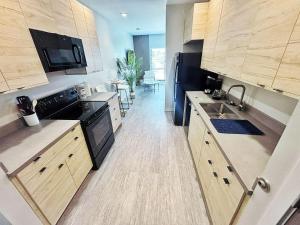 a kitchen with wooden cabinets and a black appliances at Cloud Nine Studio in Des Moines