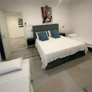 a bedroom with a large white bed with blue pillows at Crazi Suites in Nola