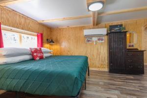 ein Schlafzimmer mit einem Bett in einem Zimmer mit Holzwänden in der Unterkunft Historic Rockaway Beach Cottage 7 in Rockaway Beach + 14 Fotos