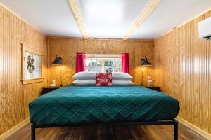 ein Schlafzimmer mit einem grünen Bett und einem Fenster in der Unterkunft Historic Rockaway Beach Cottage 7 in Rockaway Beach