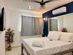 a bedroom with a large white bed with a blue wall at Comodo y brillante alojamiento para 5 in Chuburná de Hidalgo
