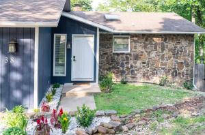 a stone house with a white door and flowers at Heron House-ON Lake Avalon - near MTB in Bella Vista +45 photos