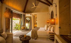 a bedroom with a bed and a living room at Hotel Muaré Tulum Wellness and Spa in Tulum +103 photos