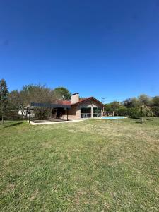 a house with a large yard in front of it at El refugio in Villa del Dique