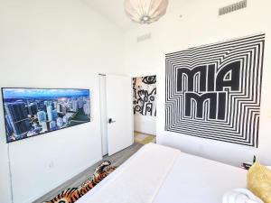 a white room with a tv and a bed at Picasso Sky Penthouse in Miami