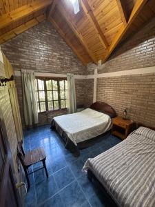 a bedroom with two beds and a wooden ceiling at El refugio in Villa del Dique +9 photos
