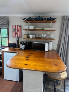 a kitchen with a wooden counter top with a microwave at Devonshire Cottage in Nottingham Road