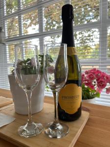 a bottle of wine and two glasses on a table at Cotswolds Retreat in Tewkesbury