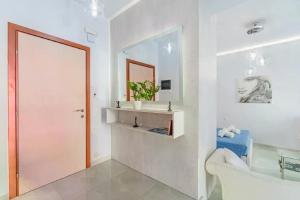 een badkamer met een bad, een wastafel en een spiegel bij La casa di San Rocco in Corfu-stad +58 foto's