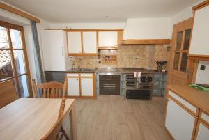 a kitchen with wooden cabinets and a stove top oven at Ferienwohnung Mountainview in Anger