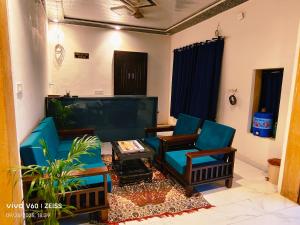 a living room with blue chairs and a coffee table at Hanu Guest house in Jaisalmer