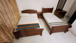 two twin beds in a room with at White House Holiday Inn in Passara