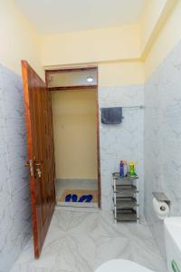 a bathroom with a toilet and a door in a room at Marvel Homes in Ruiru