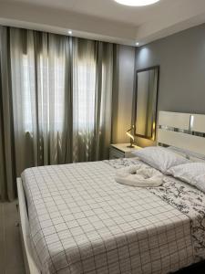 une chambre avec un grand lit blanc avec un miroir dans l'établissement Luxurious and cozy apartment, à San Luis