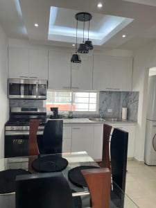 une cuisine avec une table, des chaises et une cuisinière dans l'établissement Luxurious and cozy apartment, à San Luis