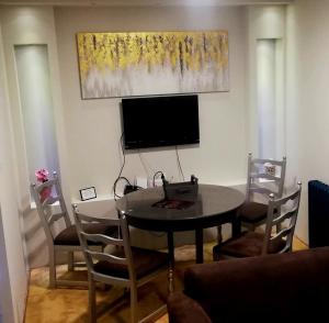a dining room table with chairs and a television at Apartman 993 in Pale