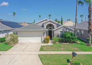 a house with a driveway and palm trees at Magic Retreat Orlando in Davenport