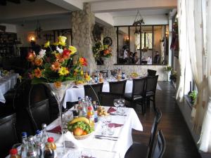 a restaurant with tables and chairs with flowers on them at Pension Casa Drumetului in Piatra Neamţ