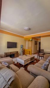 Una sala de estar con sofás y una mesa de café. en Rubz family home, en Nairobi