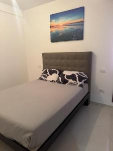 a bed in a bedroom with a picture on the wall at Penthouse Ocean View in Mindelo