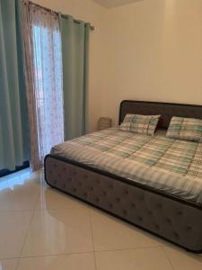 a bed sitting in a room with a window at Penthouse Ocean View in Mindelo +2 photos