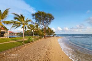 a sandy beach with palm trees and the ocean at Cinnamon Bey Beruwala in Bentota