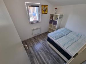 a small bedroom with a bed and a window at Luna's Seaview Residence - Ankaran in Ankaran