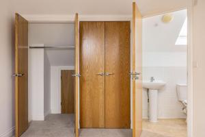 a bathroom with a wooden closet and a sink at Family Home 3 bed 3 bath with parking Garden in Chislehurst +32 photos