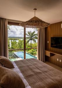 une chambre avec un lit et une vue sur une piscine dans l'établissement Villa Das Contas Boutique, à Itacaré