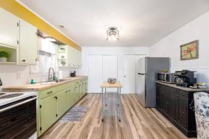 a kitchen with green cabinets and a refrigerator at Cozy Apartment in Downtown Elizabethton in Elizabethton