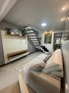 a living room with a couch and a staircase at Casa Amazônia Belém Próxima ao Hangar COP30 in Belém