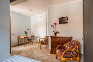a room with two chairs and a table and a television at Cavallo Bianco in Chivasso
