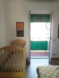 a bedroom with a crib and a sliding glass door at A&V Apartment in Santa Margherita Ligure