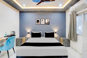 a bedroom with a bed and a blue wall at Hotel O Grand stay hotels in Karīmnagar