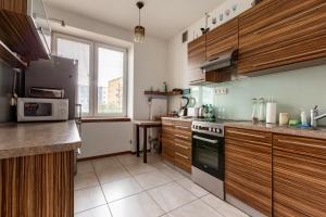 una cucina con mobili in legno e un forno a piano cottura di Marina Harmony Apartment by BookingHost a Gdynia