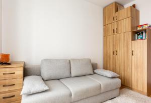 un soggiorno con divano e mobile in legno di Marina Harmony Apartment by BookingHost a Gdynia
