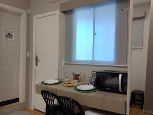 a kitchen with a table with chairs and a microwave at Suíte Luxo na Casa 68 in Belém