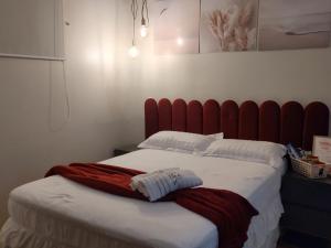 a large bed with a red headboard in a room at Suíte Luxo na Casa 68 in Belém