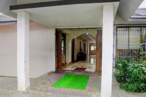 an open door of a house with a green floor at Hotel O GN Motel in Mumbai +23 photos