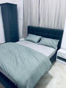 une chambre avec un lit avec une tête de lit bleue dans l'établissement Jawara Kunda Apartments, à Tujering