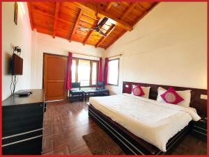 a bedroom with a bed and a desk in it at Hotel Sapphire Stay- A Luxury Resort with All Room Attached Balcony and Valley View - Wifi - Restaurant - Parking and Children Play Ground Available - Best Resort in Nainital in Nainital