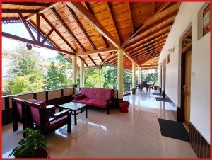 a living room with a pink couch and a table at Hotel Sapphire Stay- A Luxury Resort with All Room Attached Balcony and Valley View - Wifi - Restaurant - Parking and Children Play Ground Available - Best Resort in Nainital in Nainital