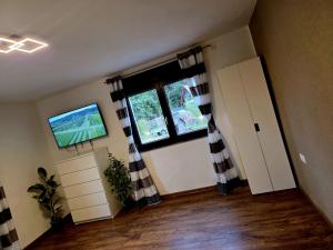 a living room with a television and a window at Ferienwohnung zum Backstübchen in Altenrode