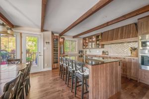 ストーンハムにある16-Chalet à louer Stonehamのキッチン(木製キャビネット付)、バー(スツール付)