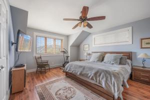 ストーンハムにある16-Chalet à louer Stonehamのベッドと天井扇風機のある寝室