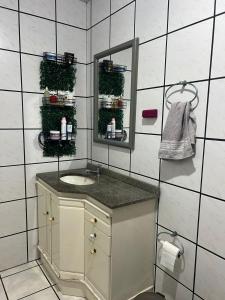 a bathroom with a sink and a mirror at Apartamento praia do Gravata e prox Beto Carrero in Navegantes