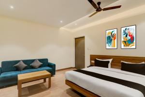 a bedroom with a bed and a blue couch at Hotel O CITI VISTA in Gorakhpur