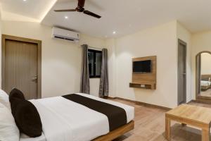 a bedroom with a large bed and a television at Hotel O CITI VISTA in Gorakhpur