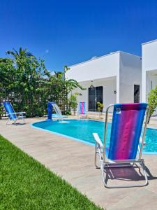 a pair of chairs sitting next to a swimming pool at Recanto Mar & Sol in Canguaretama