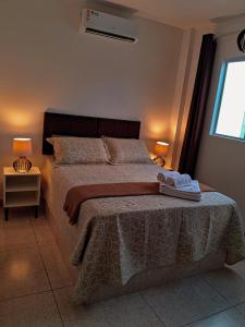 a bedroom with a bed with a blanket and two lamps at Recanto Mar & Sol in Canguaretama +13 photos